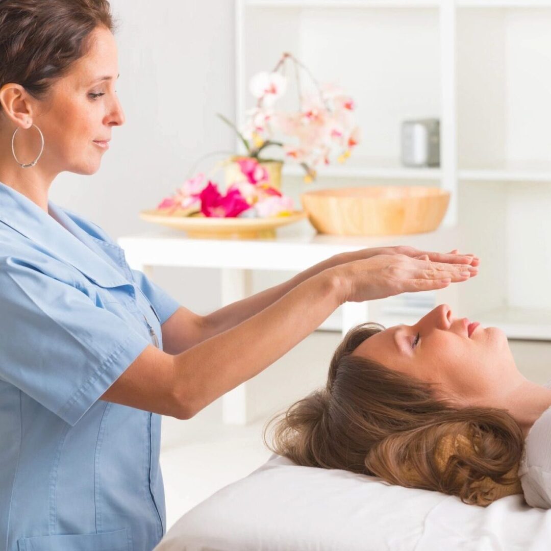 A woman is getting reiki treatment from an expert.